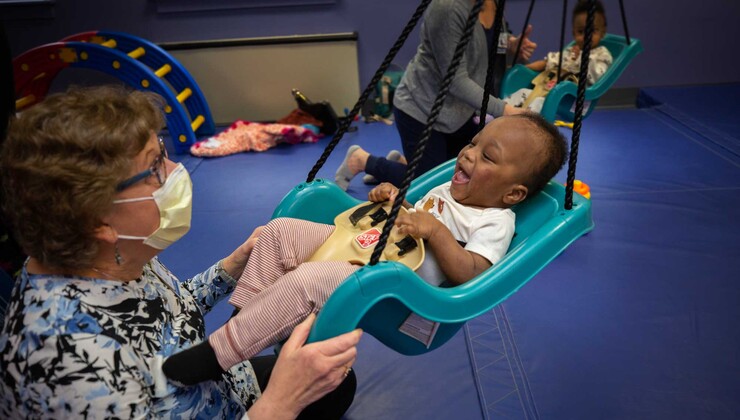 Una terapeuta ocupacional empuja a un niño en un columpio