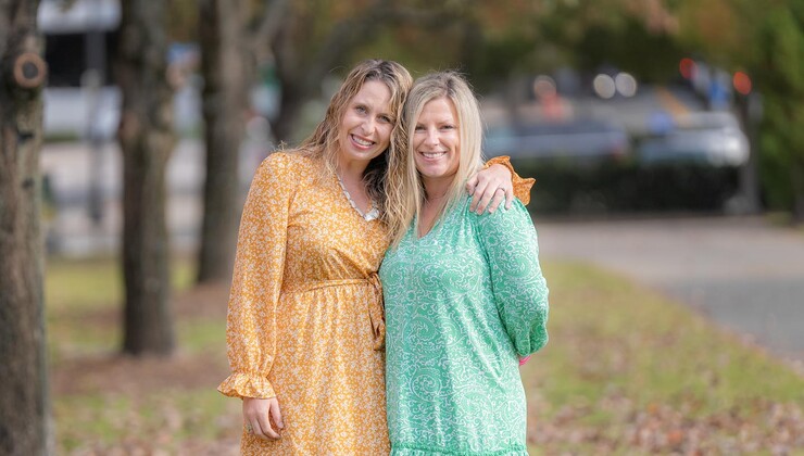 Ashley and Ginny smile outside together.