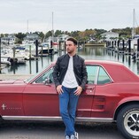 Harvey Squires stands in front of his 1967 Mustang at a marina.